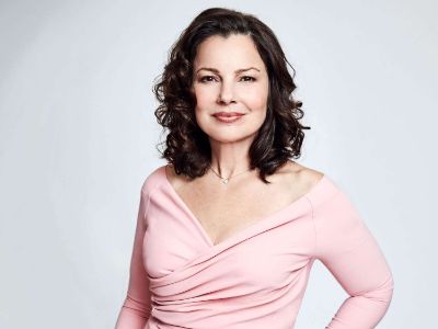 Fran Drescher is posing in a pink dress.